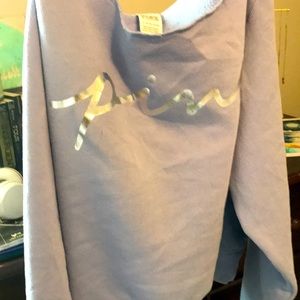 This is a purple sweater or hoodie with the word pink in silver.